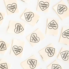 Sarah Hearts Weblabels „Thanks I Made It" locker verteilt auf weißem Untergrund