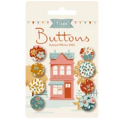 Verpackungskarte mit 8 Tilda-Knöpfen der Kollektion Village Life in Rost- und Ochertönen vor einer Illustration eines rosa Ladengeschäfts.