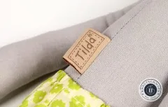 Eingenähtes Tilda-Markenlabel am Bein der Elefantenpuppe neben der gemusterten Hose.