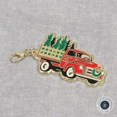 Nahaufnahme des Anhängers in Form eines roten Trucks mit Weihnachtsbaum-Ladung.