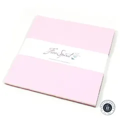 Layer-Cake-Stapel „Designer Solids Mythical" mit Free-Spirit-Banderole, angeschnitten von oben fotografiert.