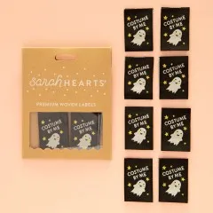 Kraftpapier-Verpackung der Sarah Hearts Weblabels "Costume by Me" mit goldglitzerndem Geist-Motiv auf schwarzem Hintergrund.