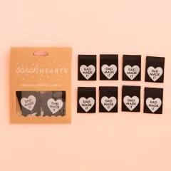 Kraftpapier-Verpackung der Sarah Hearts Weblabels "Dad Made It" in Herzform auf schwarzem Hintergrund.