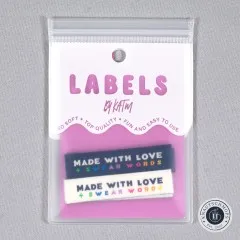 Verpackungskarte „Labels by KATM" mit den „Made With Love & Swear Words"-Labels in Marineblau und Creme, gerade von vorne fotografiert.