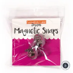 Frontale Ansicht der Verpackung der pinkfarbenen Sassafras Lane Magnetic Snaps mit Markenlogo und Produktbezeichnung „Magnetic Snaps".