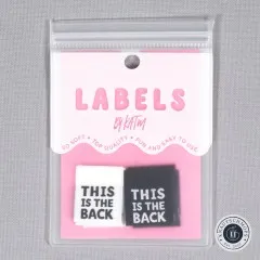 Frontalansicht der pinkfarbenen Verpackung mit je einem weißen und schwarzen Label 'This is The Back'