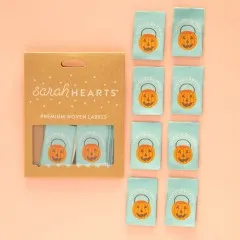 Kraftpapier-Verpackung der Sarah Hearts Weblabels "Costume by Mom" mit orangefarbenem Kürbiseimer-Motiv auf mintgrünem Hintergrund.