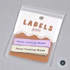 Verpackung der Kylie and The Machine Endfalz-Labels 'Hand-Fucking-Made' in Flieder und Creme.