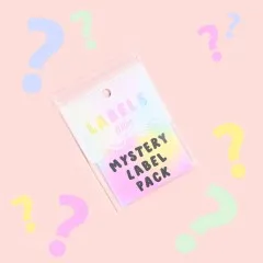 Verpackungskarte des „Mystery Label Pack" auf rosa Hintergrund, umgeben von bunten Fragezeichen als Symbol für die Überraschungsauswahl.