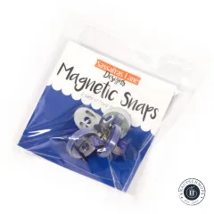 Originalverpackung der Sassafras Lane Magnetic Snaps mit dem Hinweis „2 sets of royal blue snaps", schräg fotografiert mit Blick auf die blauen Druckknopf-Teile.