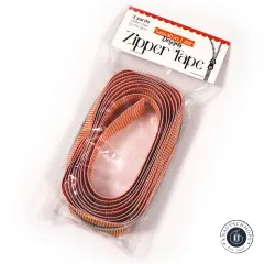 Verpackungsbeutel 'Zipper Tape' von Sassafras Lane Designs mit rotem Etikett, schräg liegend, durchsichtige Verpackung zeigt das orange-weiß gestreifte Band.