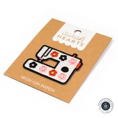 Verpackungskarte des Nähmaschinen-Patches schräg fotografiert, mit Knautschmops-Logo im Bild.