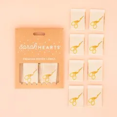 Verpackung der Sarah Hearts Weblabel „Stork Scissors" mit acht naturfarbenen Labels und goldenem Storchenscheren-Aufdruck.