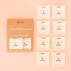 Verpackung der Sarah Hearts Weblabel „Started/Finished" mit acht cremefarbenen Bio-Baumwoll-Etiketten zum Ausfüllen.