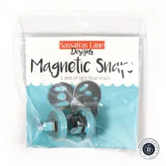 Vorderseite der Verpackung 'Magnetic Snaps' von Sassafras Lane Designs mit Aufschrift '2 sets of light blue snaps'.