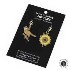 Die Zipper-Charms-Karte mit Vogel- und Sonnenblumen-Anhänger in schräger Perspektive.