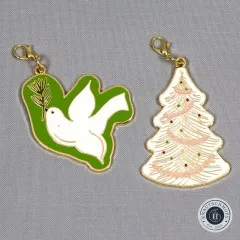 Die 'Sew Merry Zipper Charms'-Karte mit Weihnachtsbaum- und Tauben-Anhänger in schräger Perspektive.
