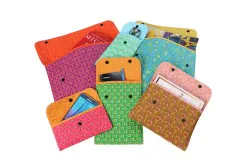 Vertikale Snappy-Sleeves-Hüllen in bunten Farben, gefüllt mit Smartphone, Buch, Brille und Karten.