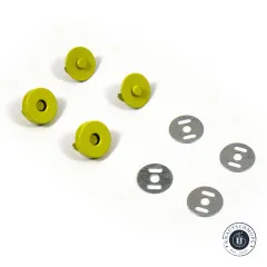 Vier gelbgrüne Magnet-Druckknopf-Hälften und vier ovale Metall-Unterlegscheiben locker auf weißem Untergrund verteilt.