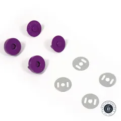 Vier violette Magnet-Druckknopf-Hälften und vier ovale Metall-Unterlegscheiben locker auf weißem Untergrund verteilt.
