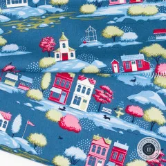 Nahaufnahme des blauen Tilda Stoffes Village Blue mit roten und rosa Häusern, Bäumen und Hunden