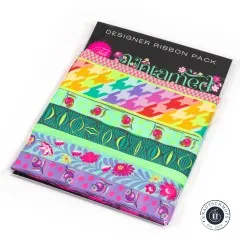 Verpackung des Tula-Pink-Webband-Sets „Untamed" in Moonbeam mit sieben unterschiedlich breiten Bändern in Grün-, Aqua- und Rosatönen.