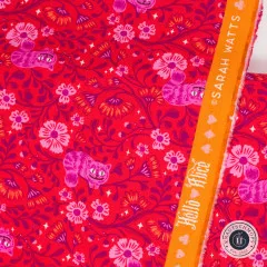 Nahaufnahme der bedruckten Webkante in Orange mit Schriftzug „Hello Alice“, Designerangabe „Sarah Watts“ und Spielkarten-Symbolen.