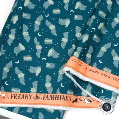 Webkante mit Aufschrift Freaky Familiars und Ruby Star Society am petrolfarbenen Fledermausstoff