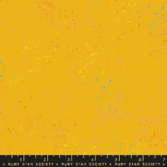 Webkante des Speckled-Stoffs in Goldenrod mit aufgedrucktem Schriftzug "Ruby Star Society" und Zoll-Maßband.