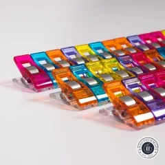Nahaufnahme aufgereihter Wonder Clips mit Metallbügel und flacher Unterseite