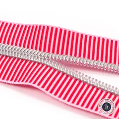 Nahaufnahme der geöffneten Zahnreihe des Reißverschlussbands Red Stripe mit silbern glänzenden Zähnen in Nickel-Finish.