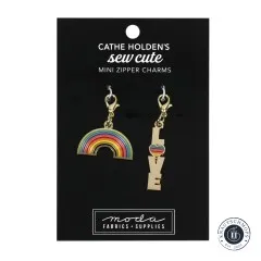 Zwei goldene Emaille-Anhänger von Cathe Holden: ein Regenbogen und der Schriftzug 'Love' mit Herz, auf Verpackungskarte 'Mini Zipper Charms'.
