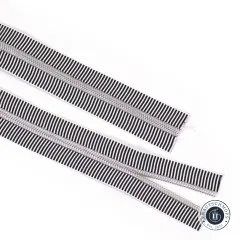 Zwei parallel liegende offene Enden des schwarz-weiß gestreiften Reißverschlussbands Black Stripe mit Nickel-Zähnen.