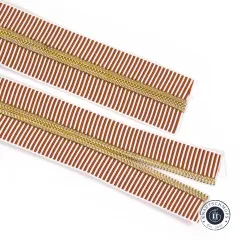 Zwei parallel liegende offene Enden des hellbraun-weiß gestreiften Reißverschlussbands Earth Stripe mit goldfarbenen Zähnen.