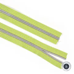 Zwei parallel liegende offene Enden des hellgrün-weiß gestreiften Reißverschlussbands Lime Stripe mit Nickel-Zähnen.