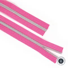 Zwei parallel liegende offene Enden des pink-weiß gestreiften Reißverschlussbands Pink Stripe mit Nickel-Zähnen.
